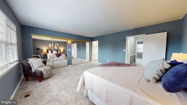 bedroom with carpet flooring, multiple windows, and multiple closets