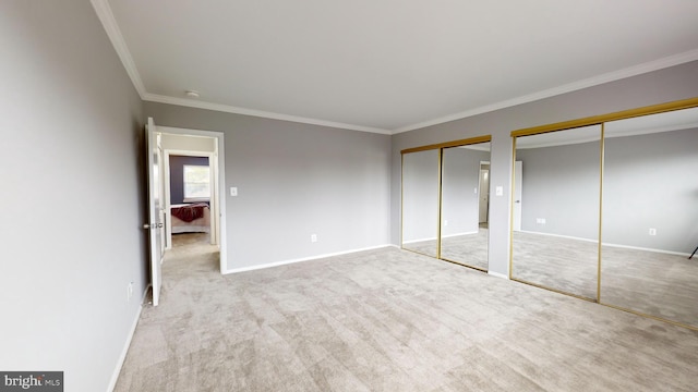 unfurnished bedroom featuring multiple closets, crown molding, and light colored carpet