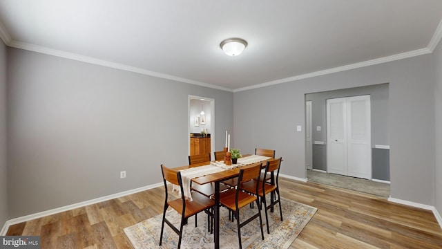 dining space featuring crown molding and light wood-type flooring