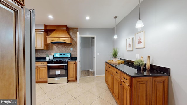 kitchen featuring tasteful backsplash, stainless steel range oven, premium range hood, decorative light fixtures, and light tile patterned floors