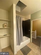 bathroom featuring tile patterned flooring and curtained shower