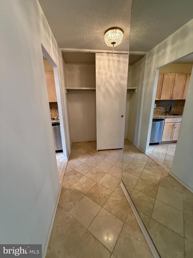 interior space with sink, light tile patterned floors, and a textured ceiling