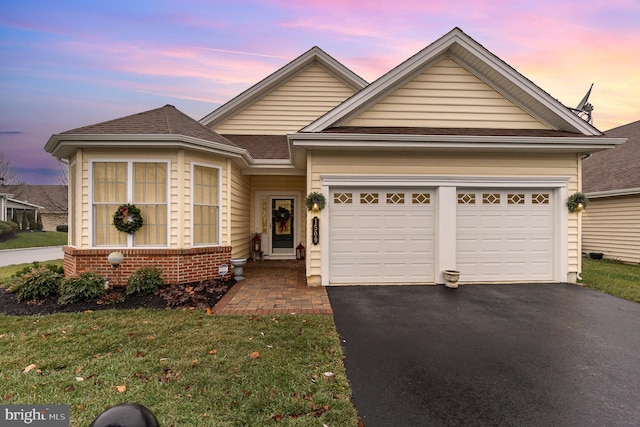 view of front facade featuring a garage and a yard