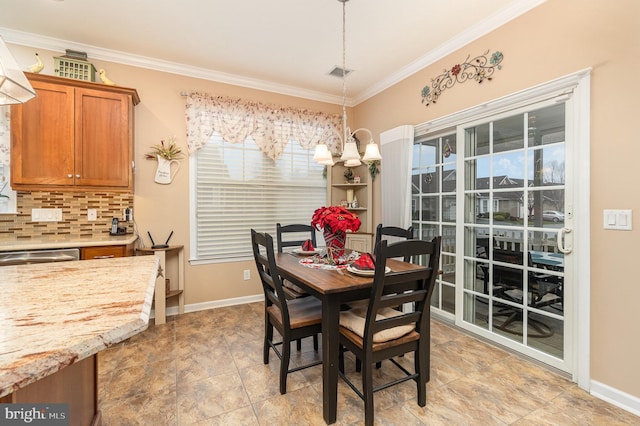 dining area featuring a chandelier, plenty of natural light, and crown molding