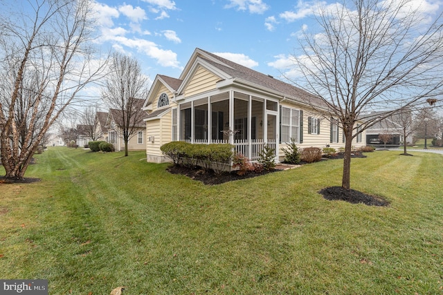 rear view of house featuring a lawn and a sunroom