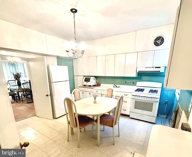 kitchen featuring pendant lighting, a notable chandelier, white cabinets, and white appliances