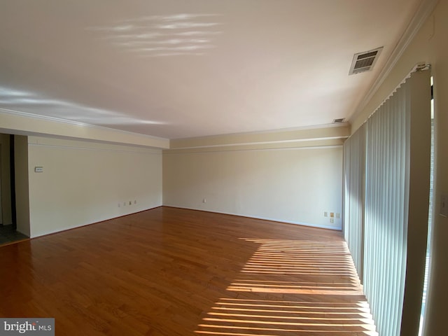 empty room featuring ornamental molding and hardwood / wood-style flooring