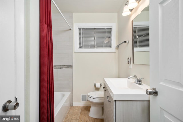 full bathroom with toilet, hardwood / wood-style floors, vanity, and shower / tub combo with curtain