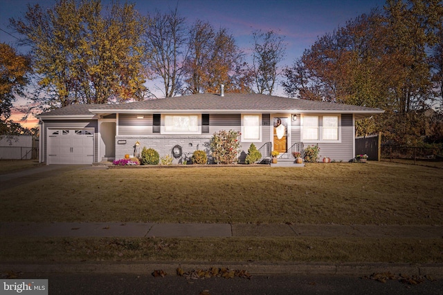 single story home featuring a garage and a yard