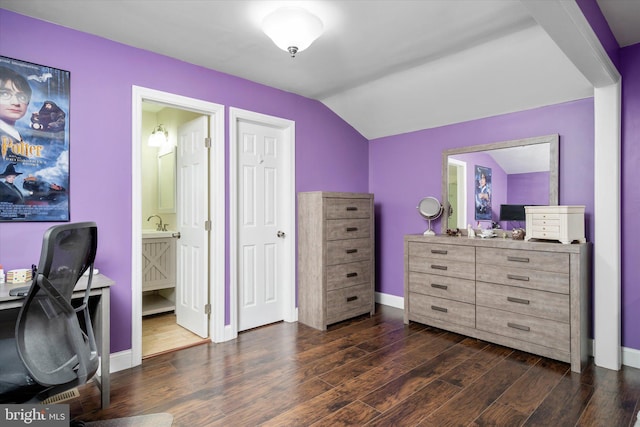 bedroom featuring ensuite bathroom, dark hardwood / wood-style floors, and lofted ceiling