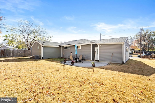 rear view of property with a lawn, central AC unit, a trampoline, and a patio