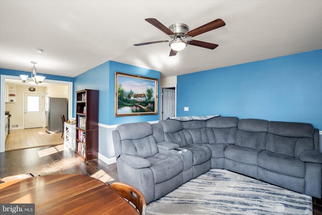 living room with wood-type flooring and ceiling fan with notable chandelier