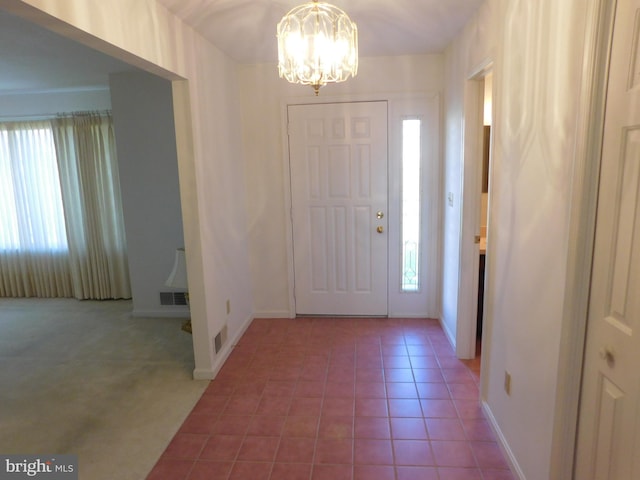 tiled foyer entrance featuring a chandelier