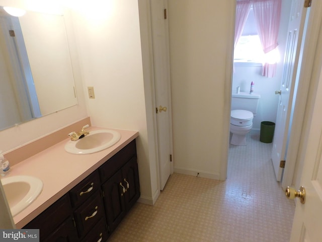 bathroom with tile patterned flooring, vanity, and toilet