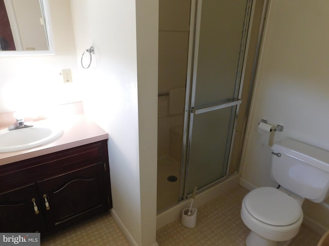 bathroom featuring vanity, toilet, and a shower with door