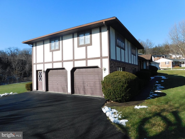 view of side of property featuring a lawn and a garage