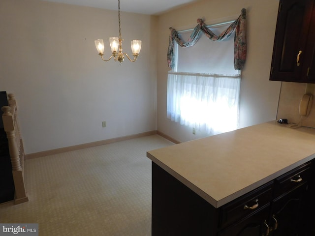 kitchen with pendant lighting, light colored carpet, and a notable chandelier