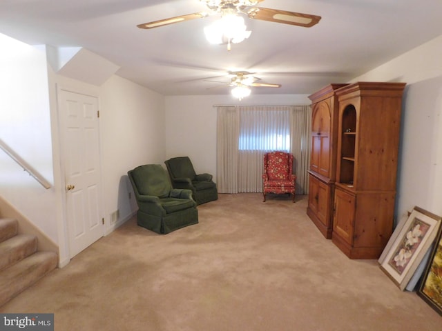 living area featuring ceiling fan and light carpet