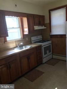 kitchen featuring white gas range, sink, a baseboard heating unit, and ventilation hood