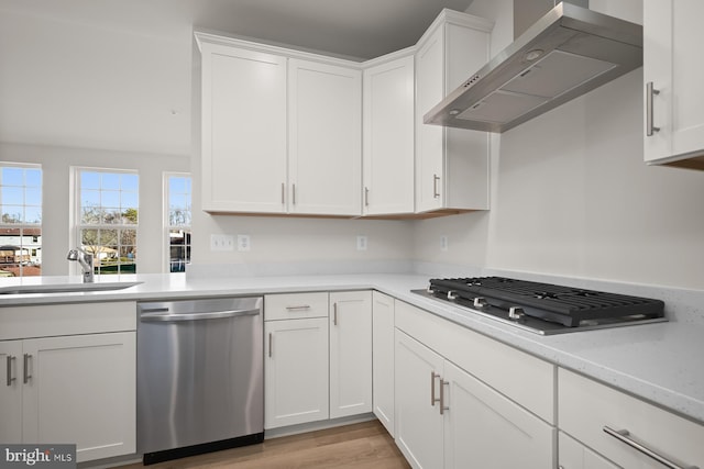 kitchen with white cabinets, dishwasher, wall chimney exhaust hood, and gas cooktop