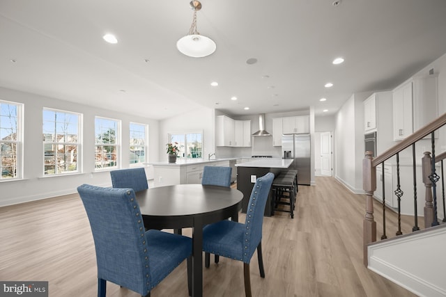 dining space featuring a healthy amount of sunlight, light hardwood / wood-style floors, and vaulted ceiling