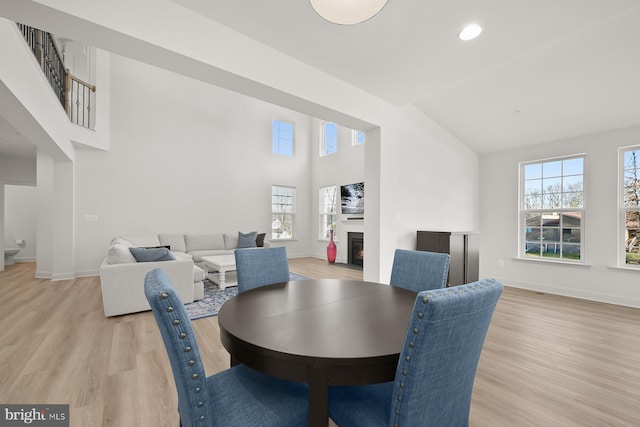 dining area with vaulted ceiling and light wood-type flooring