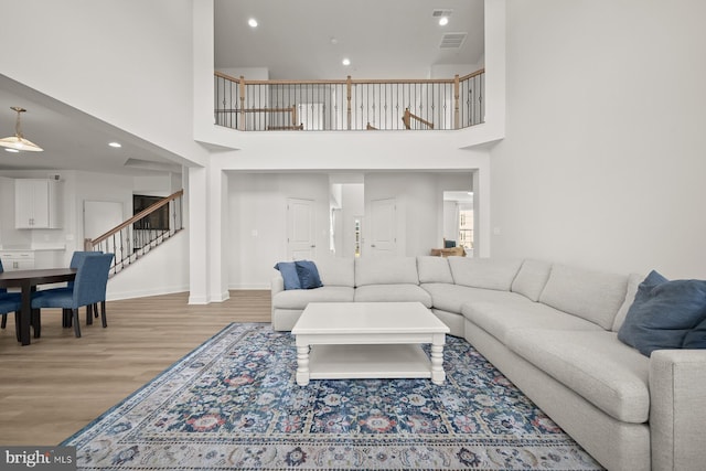 living room featuring light hardwood / wood-style flooring and a high ceiling