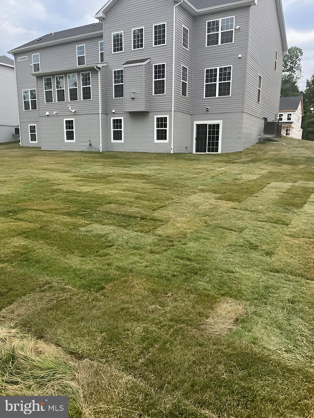 back of property with a lawn