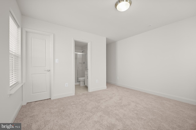 unfurnished bedroom with light carpet and ensuite bathroom