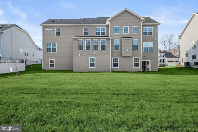 rear view of property featuring central AC and a yard