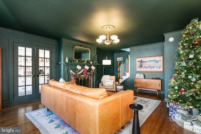 living area with a chandelier, crown molding, stairway, and wood finished floors