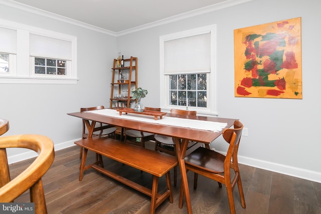 dining room with baseboards, wood finished floors, and crown molding