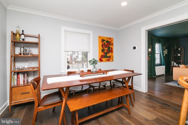 dining space featuring ornamental molding, baseboards, and wood finished floors