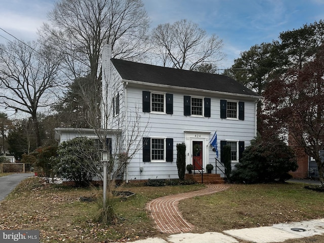 colonial home featuring a front yard