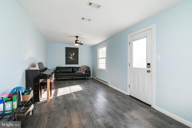 living area with baseboards, visible vents, dark wood finished floors, and baseboard heating