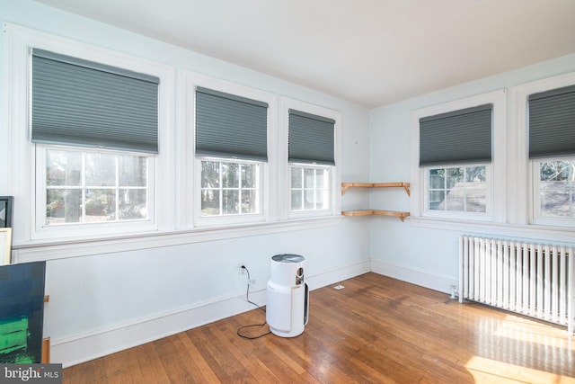 unfurnished sunroom with radiator heating unit