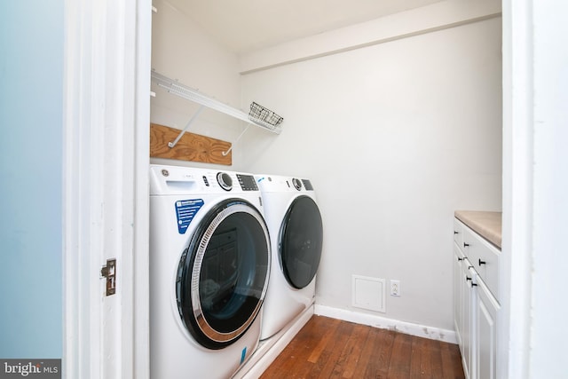 laundry room featuring cabinet space, baseboards, dark wood-style flooring, and washing machine and clothes dryer