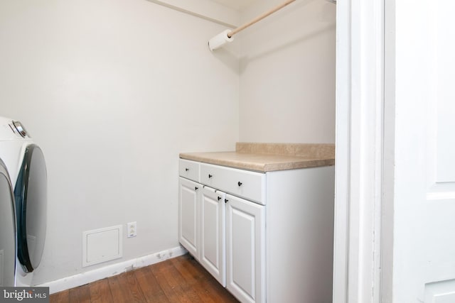 washroom featuring cabinet space, dark wood finished floors, baseboards, and separate washer and dryer