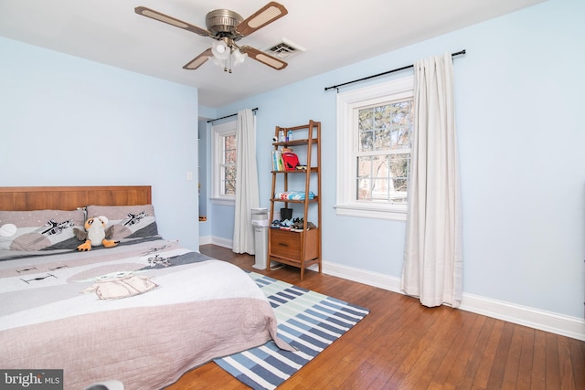 bedroom with ceiling fan, hardwood / wood-style floors, visible vents, and baseboards