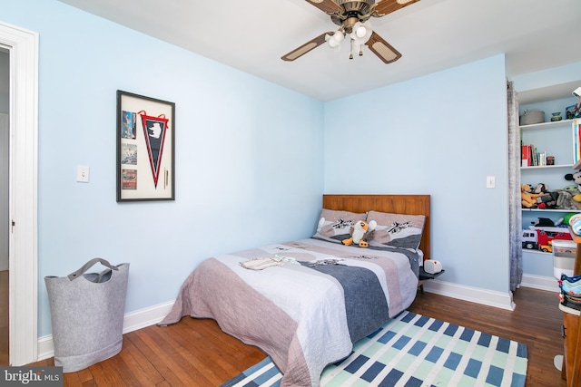 bedroom with ceiling fan, baseboards, and wood finished floors