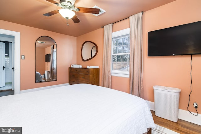 bedroom featuring a ceiling fan, baseboards, and wood finished floors