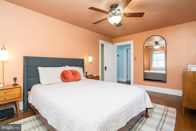 bedroom with ceiling fan, baseboards, and wood finished floors