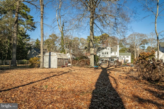 view of yard with a storage shed, an outdoor structure, and fence