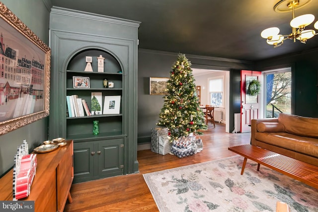 interior space with wood finished floors, crown molding, and an inviting chandelier