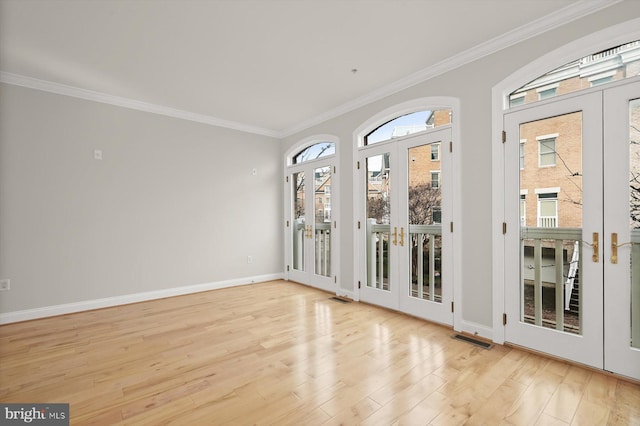 unfurnished room with crown molding, french doors, and light hardwood / wood-style flooring