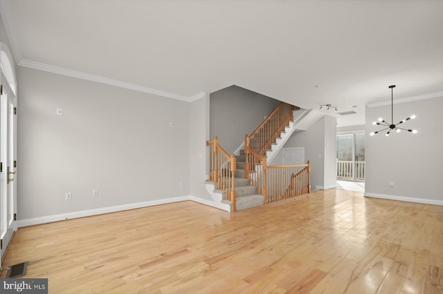 unfurnished room with light hardwood / wood-style flooring, ornamental molding, and an inviting chandelier