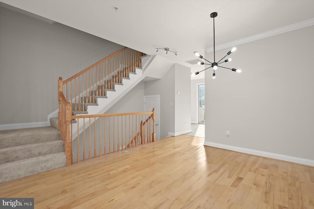 interior space featuring crown molding, light hardwood / wood-style flooring, and a chandelier