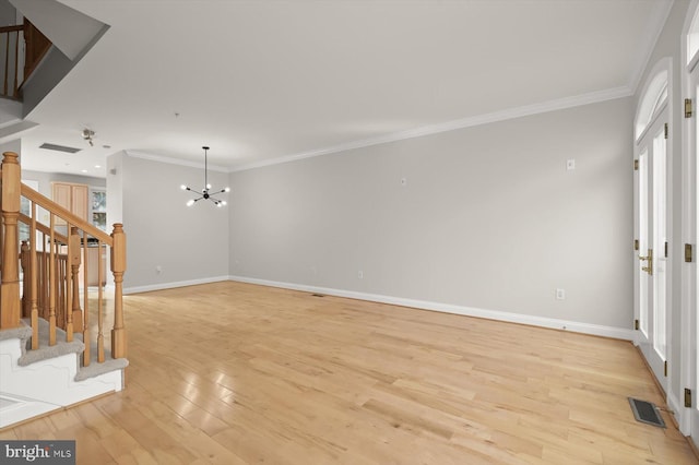 unfurnished room with light wood-type flooring, ornamental molding, a wealth of natural light, and a chandelier