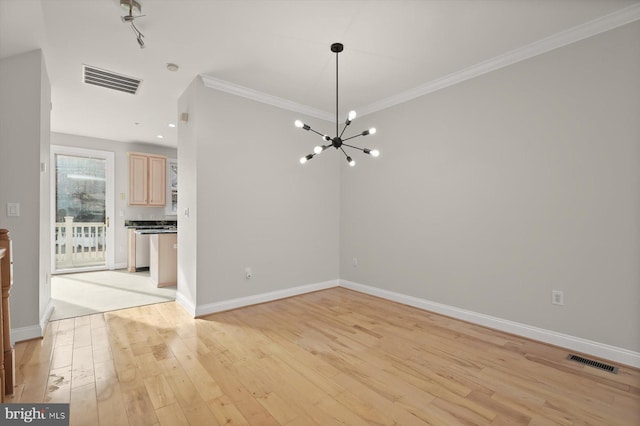 unfurnished living room with light wood-type flooring, ornamental molding, and a chandelier