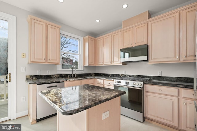 kitchen with appliances with stainless steel finishes, a kitchen island, a wealth of natural light, and sink